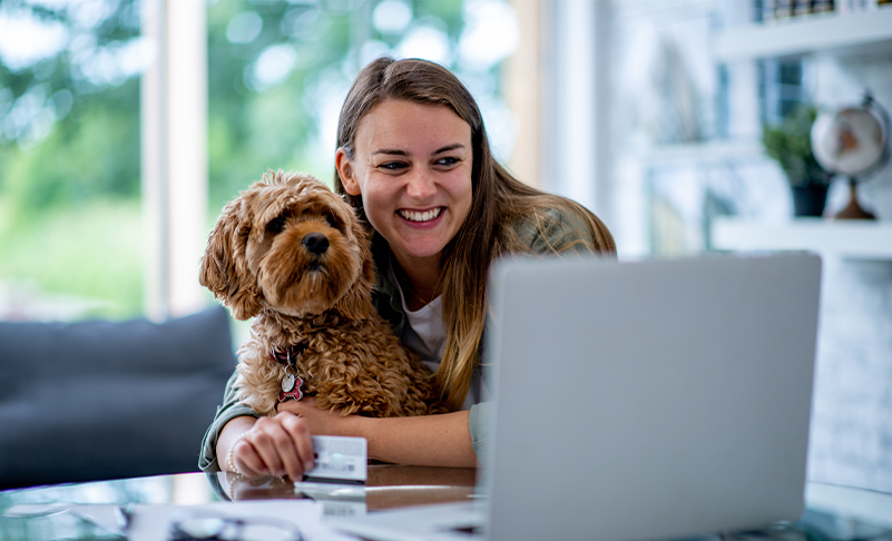 woman looking at laptop with dog